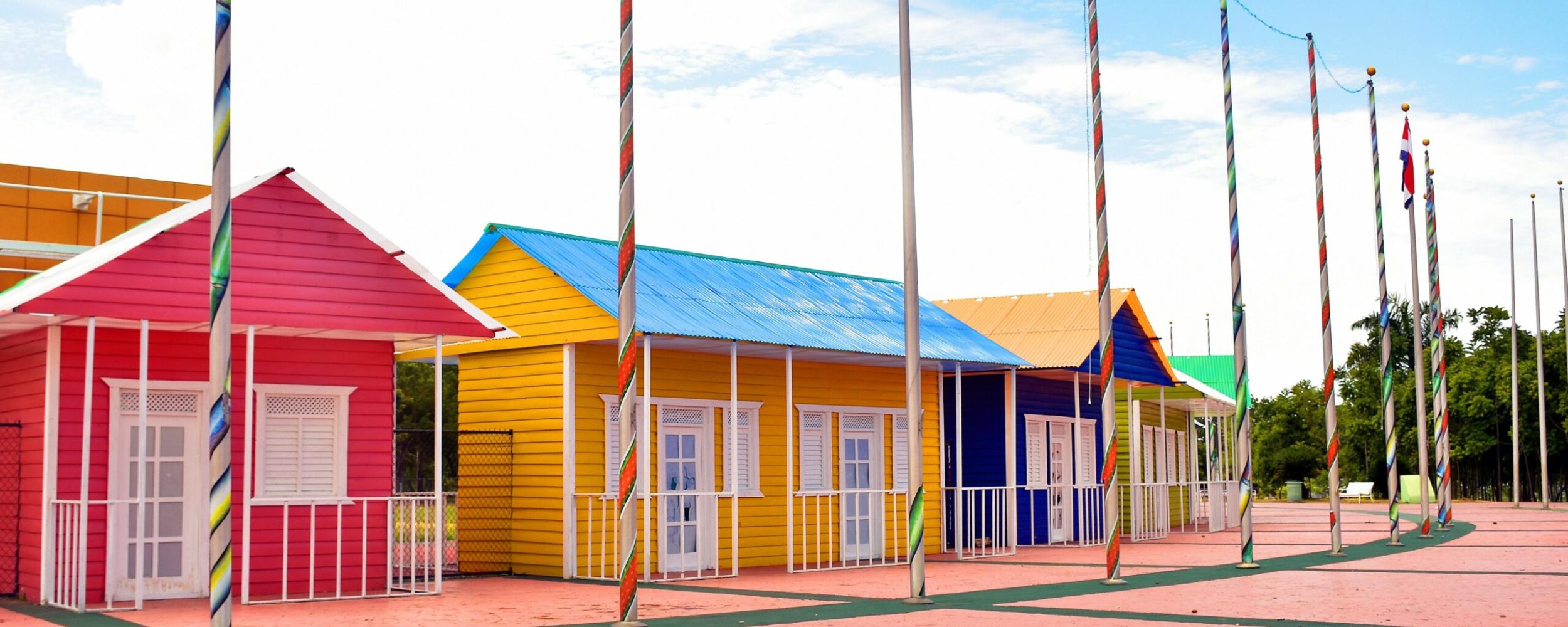 Brightly painted houses with flag poles under clear skies. Ideal for architecture and travel themes.